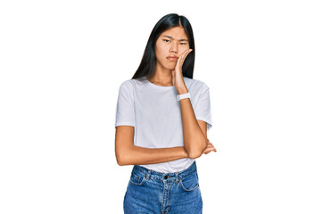 Beautiful young asian woman wearing casual white t shirt thinking looking tired and bored with depression problems with crossed arms.