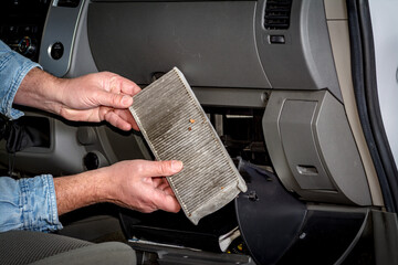 Man inspects a pickup cabin filter
