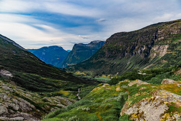 View from the road on a the valley between beautiful Norwegian mountains against  dramatic cloudy sky