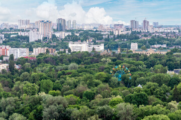 Fototapeta na wymiar Kyiv cityscape with green area and old ferris wheel on foreground