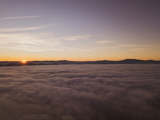 Fototapeta na wymiar Italy November 2021: aerial view of mountains with fog below in autumn season at sunset