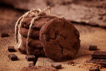 Dark chocolate cookies, with chocolate chips, on a wooden table, selective focus, close-up, no people, toned.