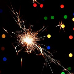 Sparkler with beautiful abstract colorful background. Concept for Christmas and Happy New Year 2022.