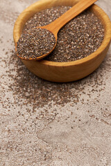 Bowl of organic natural chia seeds close-up on concrete background or table