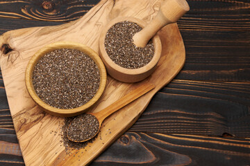 Bowl of organic natural chia seeds close-up on wooden background or table