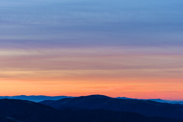 Fototapeta na wymiar Beautiful orange sky over mountain range at sunset