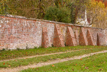 several buttress piers supporting a red brick wall of an English Country House in Fittleton, Wiltshire UK - obrazy, fototapety, plakaty