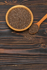 Bowl of organic natural chia seeds close-up on wooden background or table