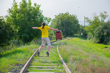 one man in yellow with a suitcase jumps on the railroad