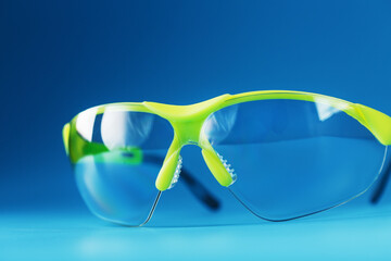 Technological protective green glasses isolated on a blue background.