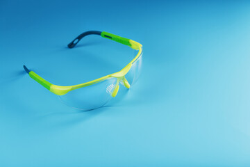 Technological protective green glasses isolated on a blue background.