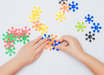 The child plays an educational game, connects plastic parts in the form of stars