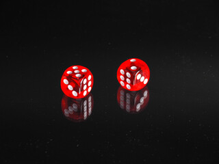 Red Dice on black background with reflection