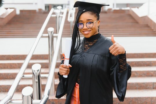 happy african american female student with diploma at graduation