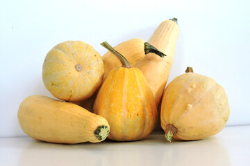 A composition of some yellow ripe raw pumpkins isolated on white background

