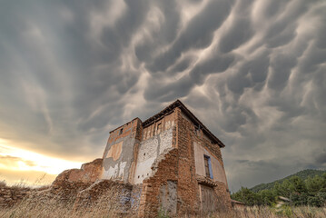 Abandoned house in the countryside with storm cumulus sky