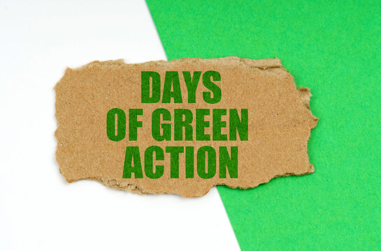 On a white-green background lies a piece of cardboard with the inscription - Days of Green Action