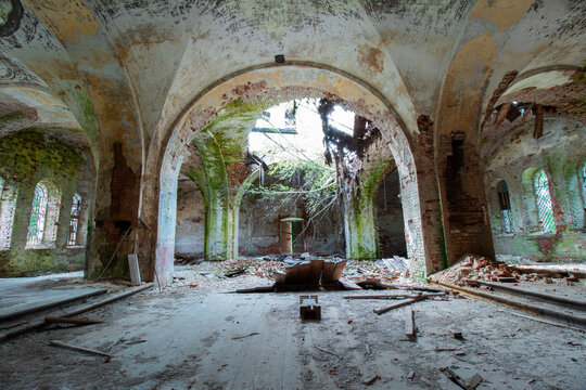 Horizontal frame of the vault of the hall of the old ruined abandoned Orthodox church in Russia. Broken floor and ceiling . Windows and a door are visible. Peeling paint. Old red brick. Daylight.