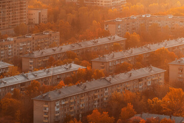 Golden autumn in the city. Sleeping areas in the rays of the sun. Trees and houses.