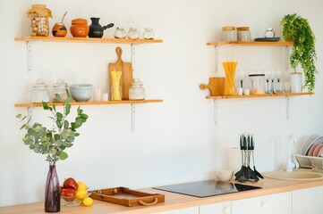 Kitchen brass utensils, chef accessories. Hanging copper kitchen with white tiles wall