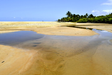 foto do encontro de um rio com o mar, na praia de trancoso, bahia.