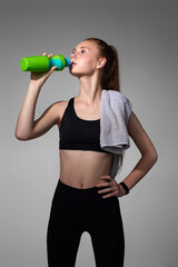 woman with towel in black sportswear drinking water