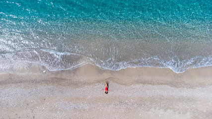 Aerial view to tropical sandy beach and blue ocean. Top view of ocean waves reaching shore on sunny day. Palawan, Philippines.
