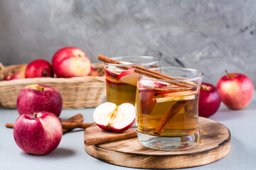 Homemade apple cider with cinnamon in glasses on a gray background. Warming winter drinks
