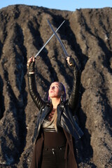 Young woman with two long bayonet knives near coal