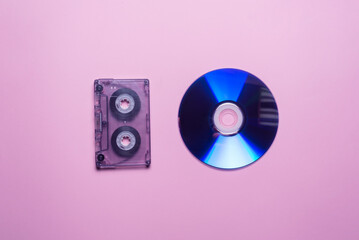 Audio cassette and cd compact disk on the pink background. Flat lay.