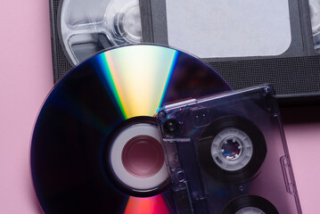 CD compact disk, audio cassette and VHS cassette close up background. Digitalization.