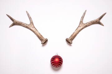 Christmas reindeer concept made of antlers and red bauble decoration