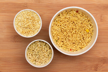 Instant Noodles in Disposable Cup on Wooden Background - Top View. Asian Fast Food. Quick Lunch