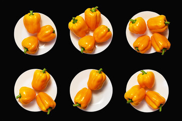 Six white plates with yellow bell peppers