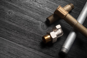 Water pipes on the black workbench background with copy space. Plumbing.