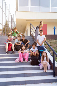 Group Of Elementary School Kids Having Fun, Sitting On The Stairs.