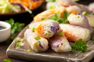 Fried Vegan spring rolls, rice paper dumplings with sweet and purple cabbage, rice noodles and carrots