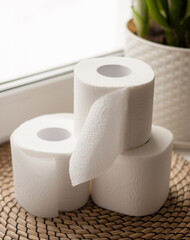 three rolls of toilet paper on a blurry background on a jute napkin