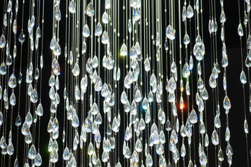 Crystal stones dangle and glisten on black background. Shining crystal chandelier.