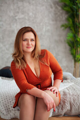 Naklejka premium Middle-aged woman in beautiful dress in the light room