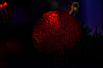 Christmas tree toy - a red shiny ball close-up and shallow depth of field.