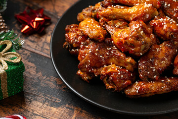 Christmas Buffalo chicken wings with decoration, gifts, green tree branch on wooden rustic table