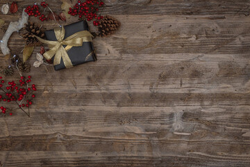 wooden surface with christmas gift, pine cones, berries and led lights with copy space