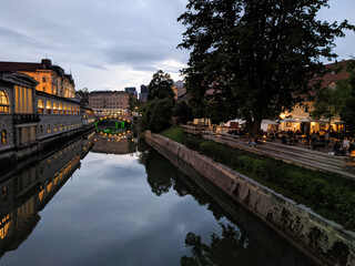 Romantic riverfront by Ljubljanica river in Ljubljana city center. Night view of green river flowing through the city center in capital of Slovenia