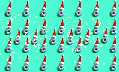 Pattern of Silver donut with sequins and red santa claus hat on green background. Festive Gift Wrapping Paper. Christmas mood