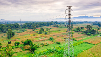 High voltage power line at morning in the middle of the field