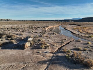 Flying above abandoned cattle ranch next to a river-bend in the desert - obrazy, fototapety, plakaty