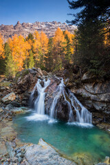 Waterfall in the heart of the forest during autumn season, Swiss Alps, Graubunden, Switzerland