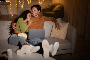 Couple Laughing Watching Comedy Movie On Laptop At Home