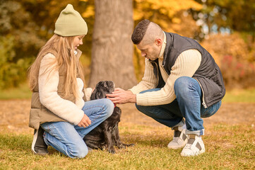 Fototapeta premium A family spending time together in the park with their dog